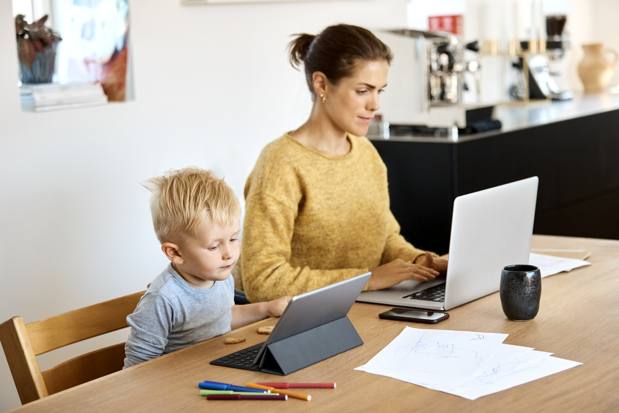 Mother and son using technologies at table